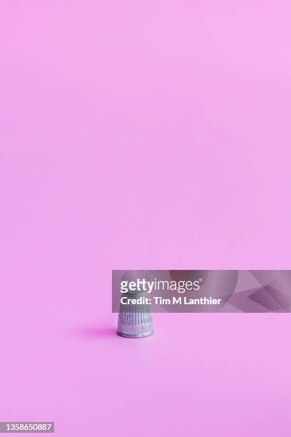 thimble on a pink background - thimble fotografías e imágenes de stock