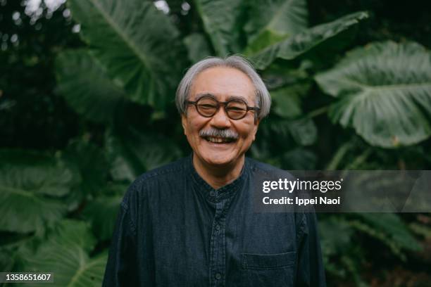 senior man laughing at camera in nature - elderly asian foto e immagini stock