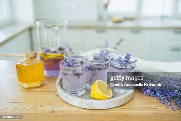 honey, glasses with ice, lemon juice and lavender cocktail on kitchen table. - cocktail recipe stock pictures, royalty-free photos & images