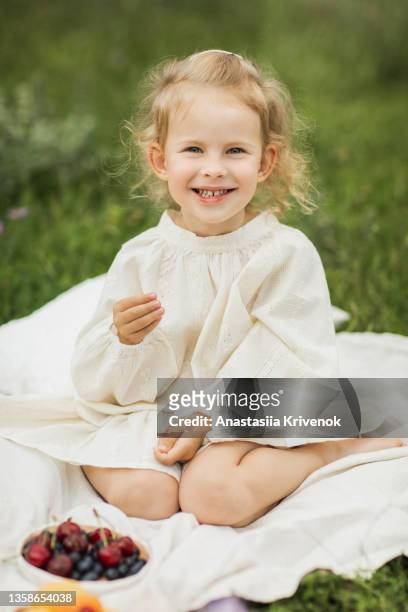 cute child enjoying summer picnic with berry's and sweet pie. - sweetie pie stock pictures, royalty-free photos & images