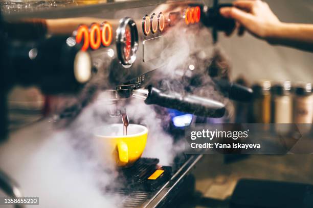 coffee machine espresso making with steam, beans extracting process and pouring the liquid from the sprouts - cafeteria imagens e fotografias de stock