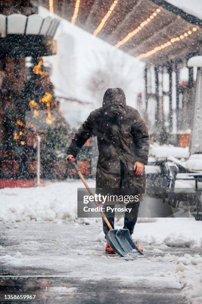 man shoveling snow after a blizzard - shoveling driveway stock pictures, royalty-free photos & images