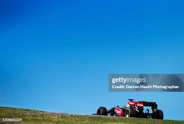 Finnish Lotus Formula One team racing driver Kimi Raikkonen driving his E21 racing car at speed in front of a blue sky during the 2013 German Grand...