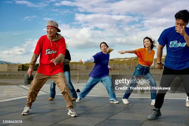 young people and senior leaders doing hiphopdance on the coast - team event ストックフォトと画像