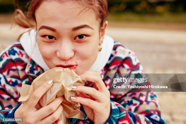 teenageer eating light meals for lunch at outdoor - woman eating burger stock pictures, royalty-free photos & images