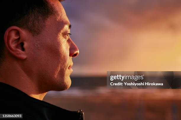 portrait of mature man on beach - horizont stock-fotos und bilder