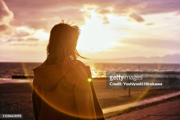 portrait of young woman on beach - erwartung stock-fotos und bilder