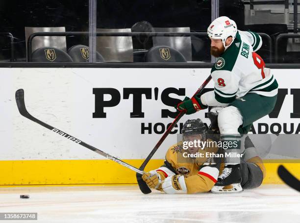 Jonathan Marchessault of the Vegas Golden Knights and Jordie Benn of the Minnesota Wild battle for the puck along the boards in the second period of...