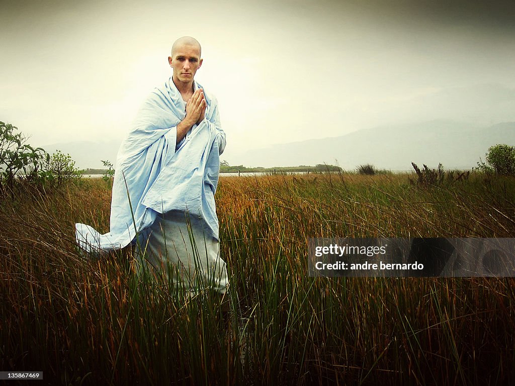 Old man walking in field with hands joining