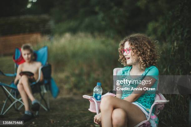 girl and boy relaxing in camping chairs - portrait of a camper stock pictures, royalty-free photos & images