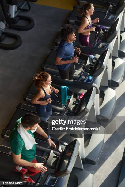 people running on a treadmills in health club - running on treadmill stockfoto's en -beelden
