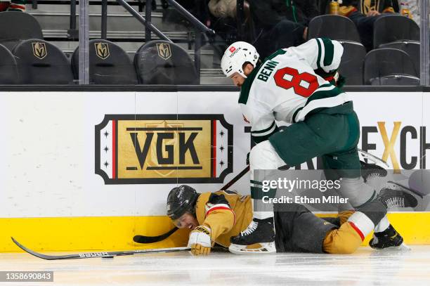 Jonathan Marchessault of the Vegas Golden Knights and Jordie Benn of the Minnesota Wild battle for the puck along the boards in the second period of...