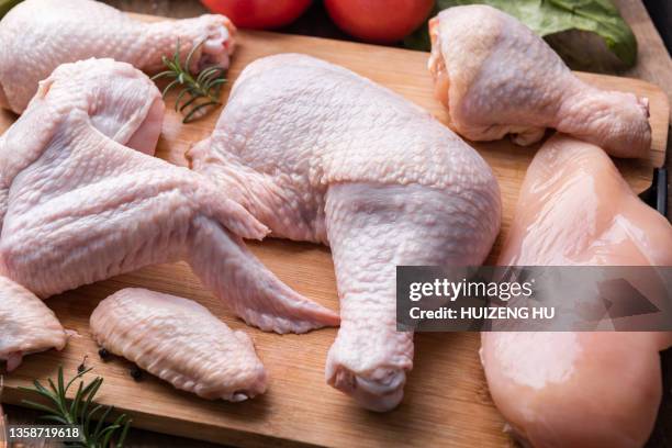 raw chicken meat on cutting board. legs wings and breast - thigh stock photos et images de collection