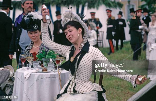 French actress Sophie Marceau spritzes herself with an aerosol can before a scene in the film 'Leo Tolstoy's Anna Karenina', 1997. The movie was...