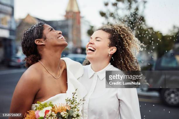 tiro de um jovem casal lésbico parado do lado de fora juntos e celebrando seu casamento - wedding - fotografias e filmes do acervo