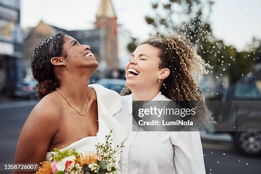 Shot of a young lesbian couple standing outside together and celebrating their wedding Shot of a young lesbian couple standing outside together and celebrating their wedding