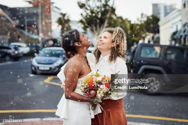 aufnahme eines jungen lesbischen paares, das zusammen draußen steht und seine hochzeit feiert - gay wedding stock-fotos und bilder
