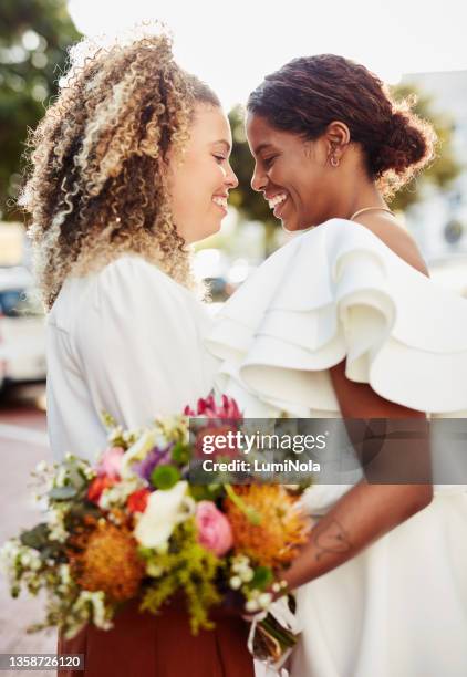 aufnahme eines jungen lesbischen paares, das zusammen draußen steht und einen romantischen moment nach ihrer hochzeit teilt - gay wedding stock-fotos und bilder