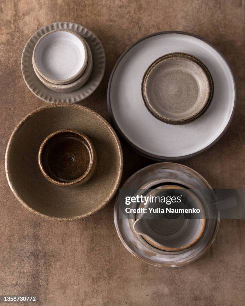 ceramic tableware on a brown background. pottery production. - ceramic stock pictures, royalty-free photos & images