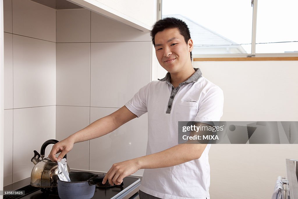 Young man heating retort pouch in boiled water
