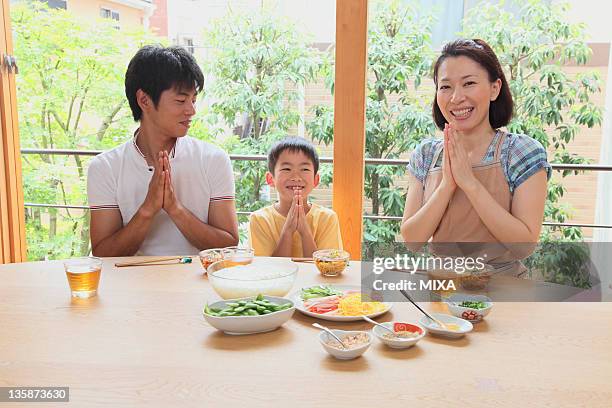 family putting hands together before meal - itadakimasu stock pictures, royalty-free photos & images