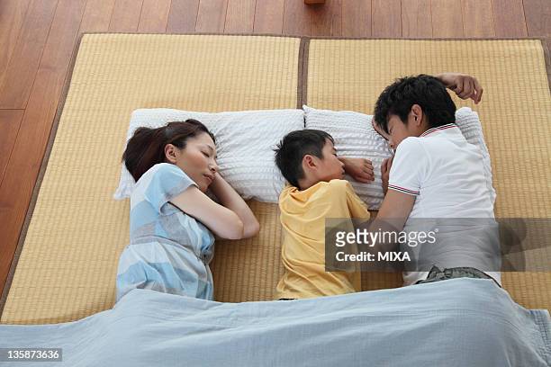 family napping on tatami mat - tatami mat stock pictures, royalty-free photos & images
