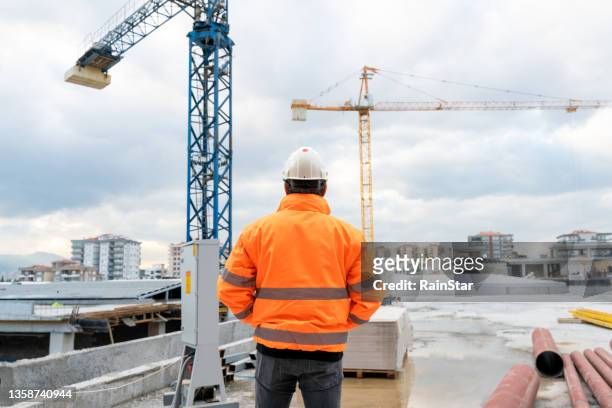 civil engineer examines work at construction site - reflecterende kleren stockfoto's en -beelden