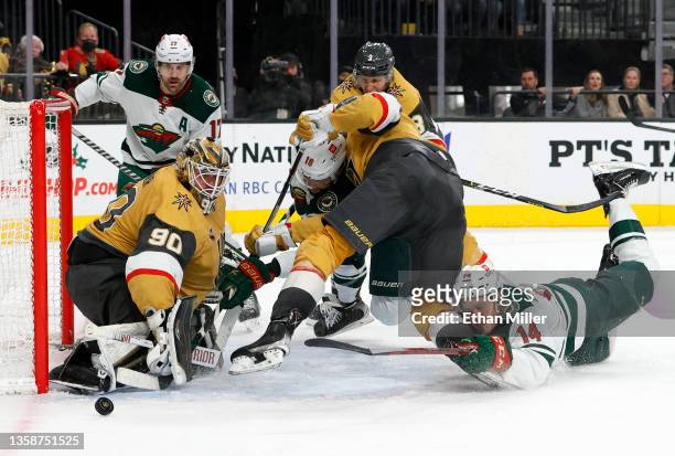 Robin Lehner of the Vegas Golden Knights makes a save as Jordan Greenway and Joel Eriksson Ek of the Minnesota Wild look for a rebound against Zach...