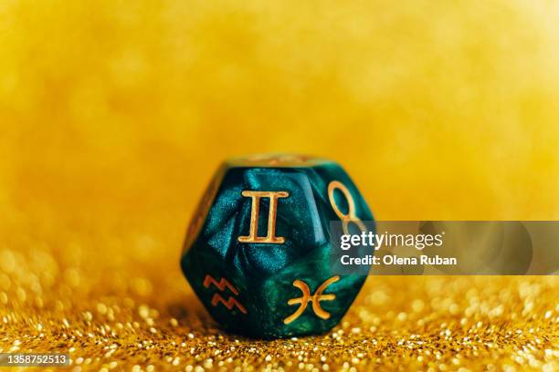 green divination dice on gold colored background. - numerology stock pictures, royalty-free photos & images