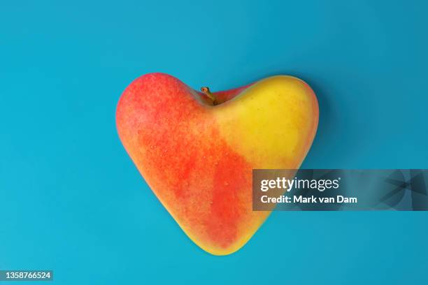 a studio photograph of a heart shaped ambrosia apple - apple heart stock pictures, royalty-free photos & images