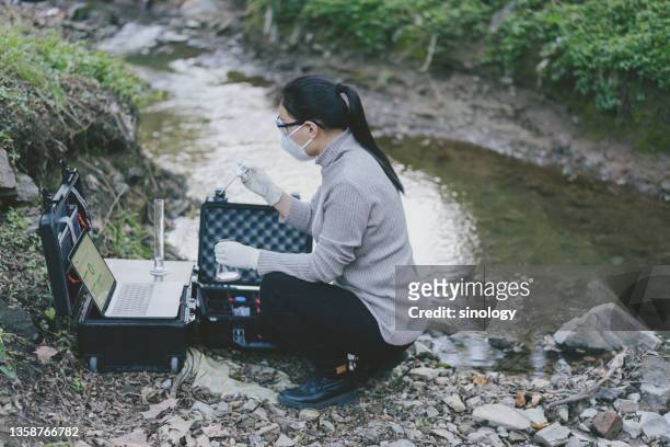 asian female scientist using laptop to measuring water quality in mountain river - data lake stock pictures, royalty-free photos & images