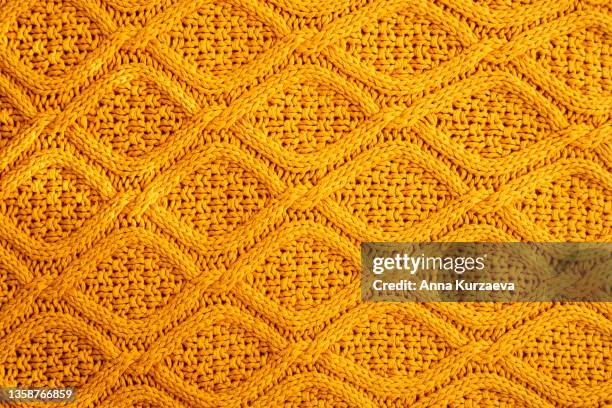 texture of warm knitted sweater. backdrop in yellow color. - lana fotografías e imágenes de stock