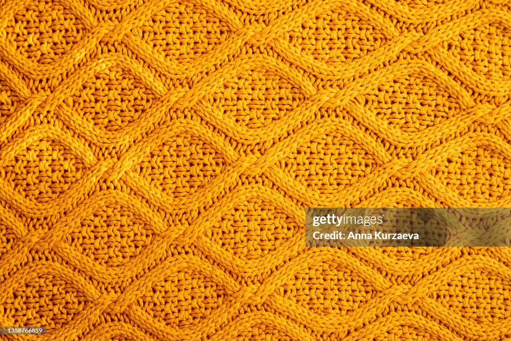 Texture of warm knitted sweater. Backdrop in yellow color.