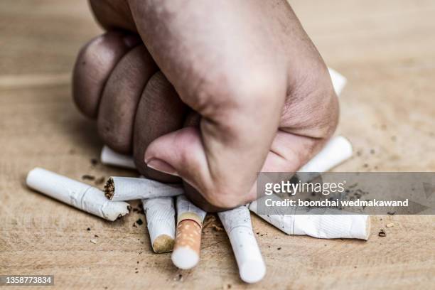 male hand destroying cigarettes - stop smoking concept - broken finger ストックフォトと画像