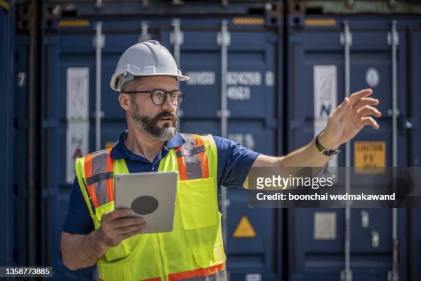 smart creative foreman engineer man control loading containers box from cargo freight ship for import export. logistic, transportation, import and export concept with copy space. - ports nsw bildbanksfoton och bilder
