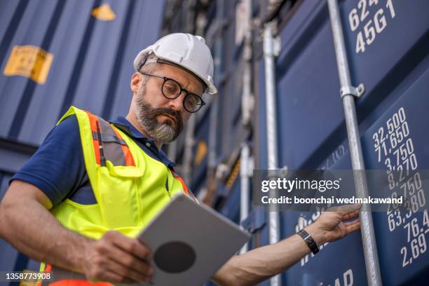 smart creative foreman engineer man control loading containers box from cargo freight ship for import export. logistic, transportation, import and export concept with copy space. - lasta bildbanksfoton och bilder