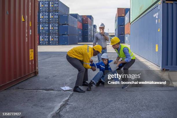 accident at construction site. physical injury accident at work of construction worker. first aid help construction worker who has an accident at a construction site. - missed train stockfoto's en -beelden