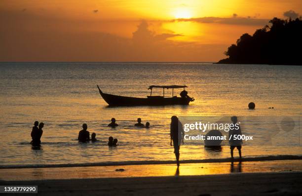 malaysia langkawi beach,silhouette of people on beach against sky during sunset - langkawi stock-fotos und bilder