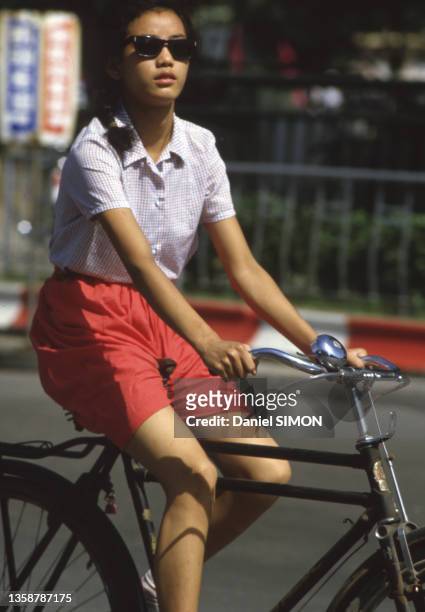 Une femme se déplace à vélo, en 1983.