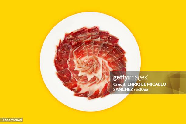 plate of iberian ham on yellow background,top view - jamón serrano fotografías e imágenes de stock