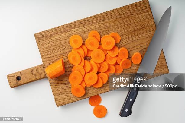 sliced carrots on a wooden cutting board - cutting board stock pictures, royalty-free photos & images