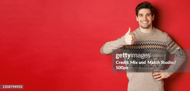 portrait of happy handsome man in christmas sweater,smiling and - weihnachtspullover mann stock-fotos und bilder