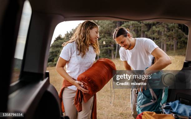 young couple preparing gear for hike - camping stockfoto's en -beelden