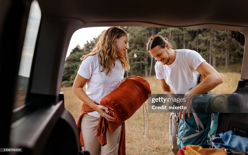 Young couple preparing gear for hike