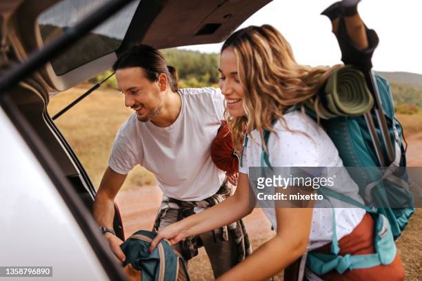 young couple preparing gear for hike - car camping luggage stock pictures, royalty-free photos & images