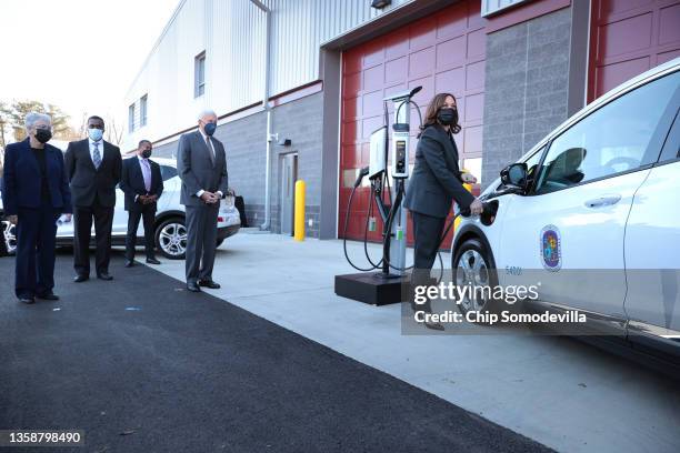 Vice President Kamala Harris plugs a Prince George’s County electric vehicle into a charging station at the Brandywine Maintenance Facility with...