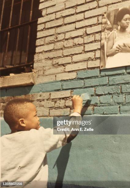 Close-up of William 'Sonny' Fletcher as he paints part of the alley wall of the Art & Soul community art center , in the Lawndale neighborhood,...