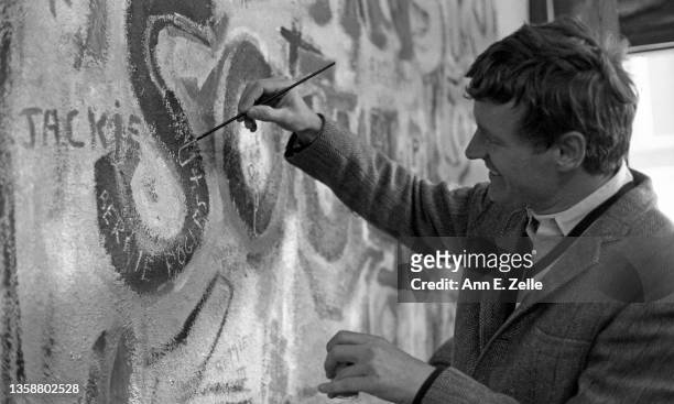 Chicago Art Institute trustee Bernard F Rogers paints his name on a wall as he attends the opening event for the Art Contest Exhibition at the Art &...