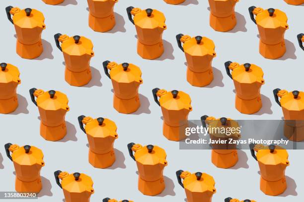 some orange moka pot italian coffee makers on gray background - coffee frappe stock-fotos und bilder