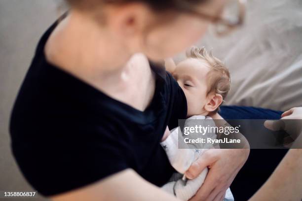 mutter stillendes baby zu hause - säugen stock-fotos und bilder